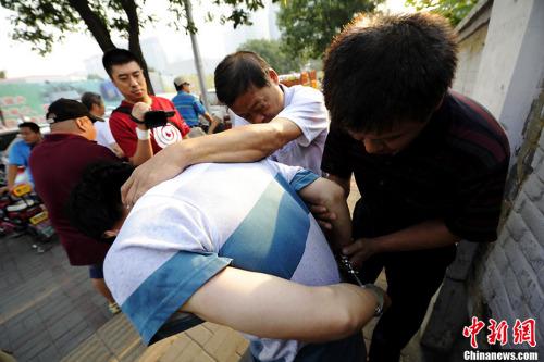 原料图：2013年8月北京西城警方在儿童病院抓获8名号市井。图片起源：CFP视觉中国