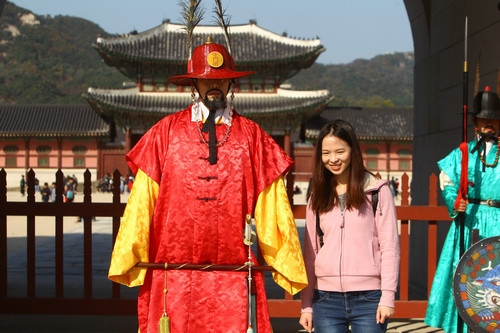  材料图片：在韩国首尔景福宫外，中国旅客与韩国守城门将合影。新华社记者 姚琪琳 摄