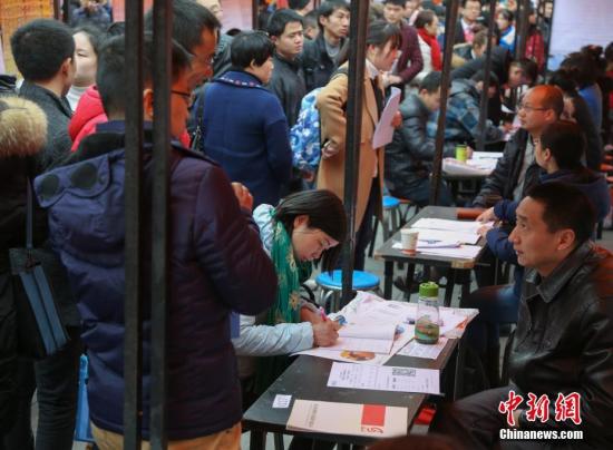 材料图：在武汉市纳杰人才市场应聘会上，挤满了前来应聘的求职者。中新社记者 张畅 摄