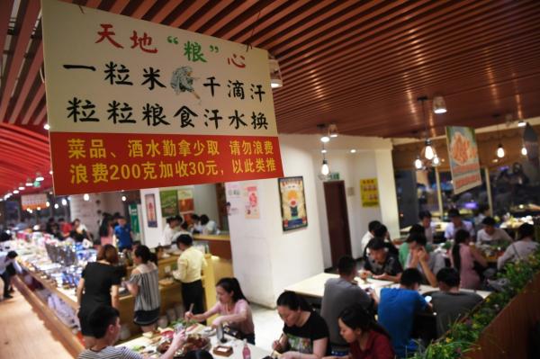 2017年6月9日，重庆市江北区不雅音桥商圈的一家自助餐厅内挂出提示花费者“勤拿少取”的口号。新华社 材料图